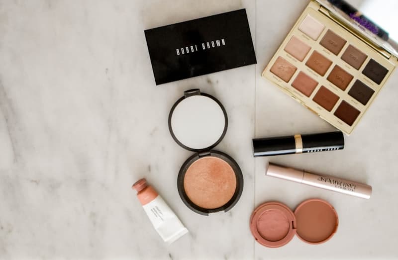 Makeup palettes, brushes and beauty products arranged on a work surface